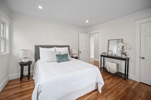 bedroom with crown molding, wood finished floors, and baseboards