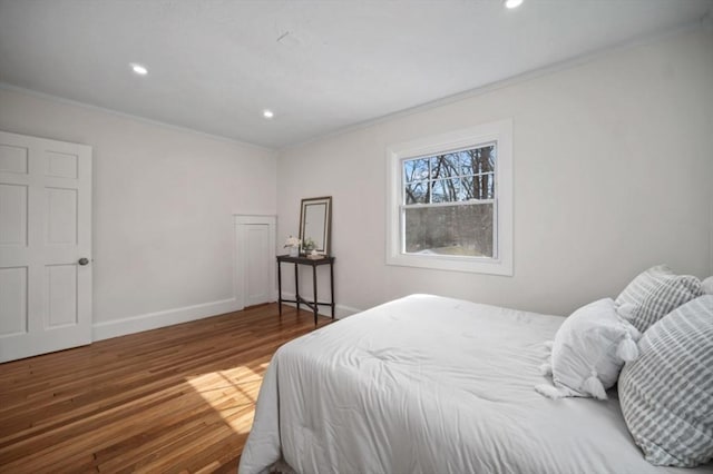 bedroom featuring recessed lighting, baseboards, wood finished floors, and crown molding