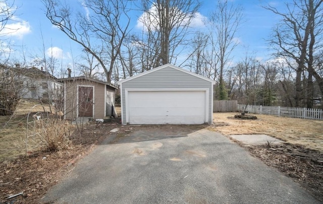 detached garage featuring fence