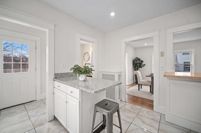 kitchen with light stone counters and white cabinets