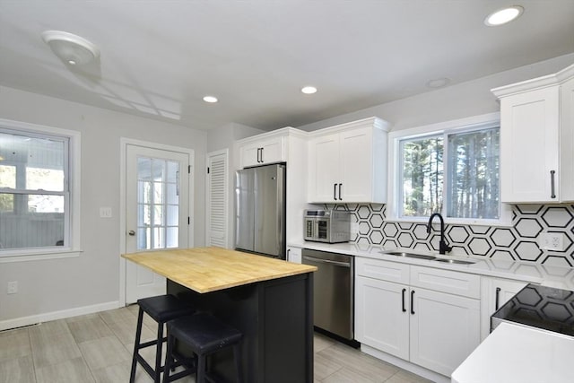 kitchen with sink, stainless steel appliances, and white cabinetry