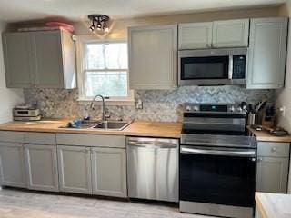 17 Ebenezer Rd, Barnstable, MA 02655 - kitchen with stainless steel appliances, light countertops, backsplash, a sink, and gray cabinetry