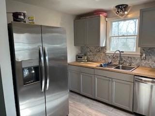 17 Ebenezer Rd, Barnstable, MA 02655 - kitchen with tasteful backsplash, a sink, stainless steel appliances, and gray cabinetry