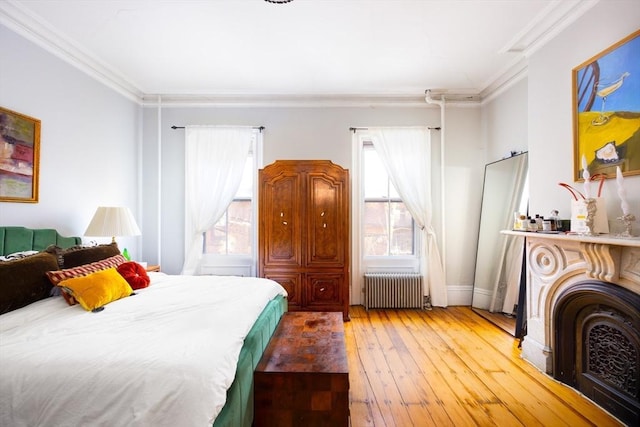 bedroom with crown molding, wood-type flooring, and radiator