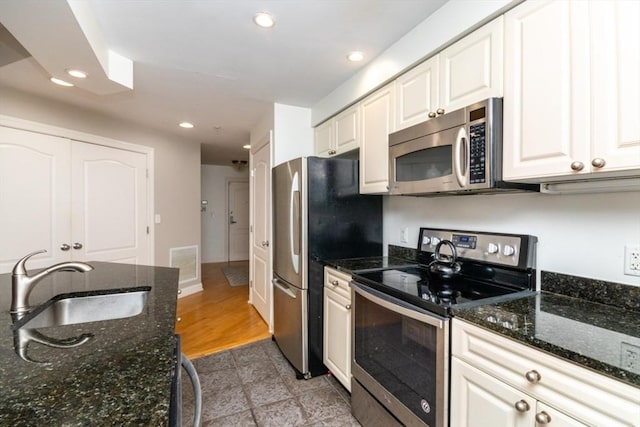 501 Commerce Dr Unit 1304, Braintree, MA 02184 - kitchen featuring appliances with stainless steel finishes, a sink, recessed lighting, white cabinets, and dark stone countertops