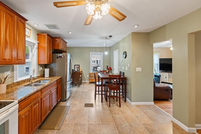 235 Union St, Northbridge, MA 01588 - kitchen featuring ceiling fan, brown cabinets, freestanding refrigerator, stone counters, and recessed lighting