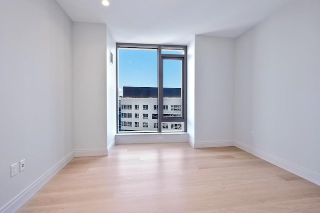 unfurnished room featuring light hardwood / wood-style floors and expansive windows