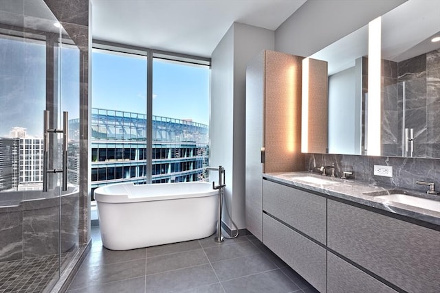 bathroom featuring tasteful backsplash, tile patterned floors, expansive windows, vanity, and separate shower and tub