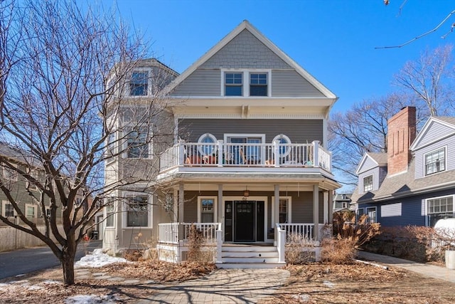 view of front facade with covered porch and a balcony