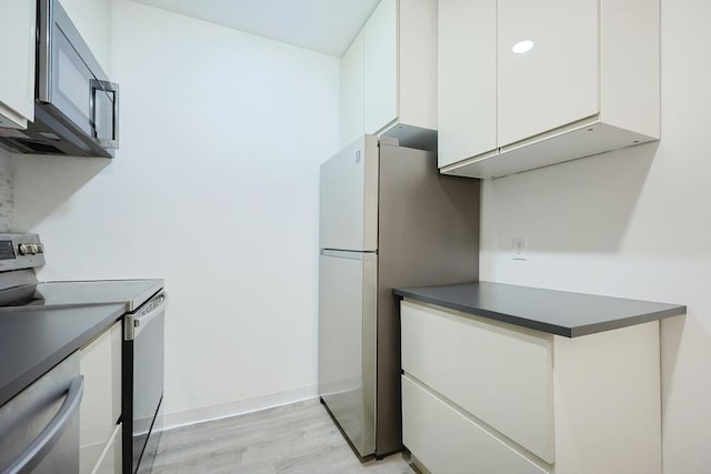 kitchen featuring light hardwood / wood-style flooring, white cabinets, and appliances with stainless steel finishes