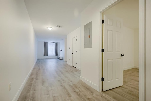 hall featuring light wood-type flooring and electric panel