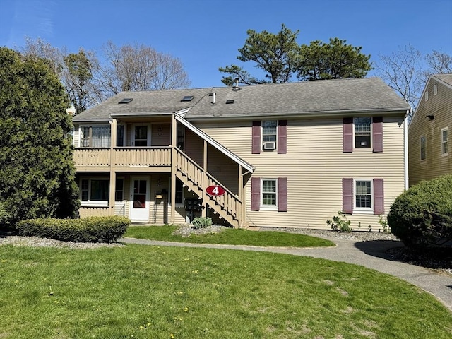 rear view of property featuring stairs, a lawn, and a wooden deck