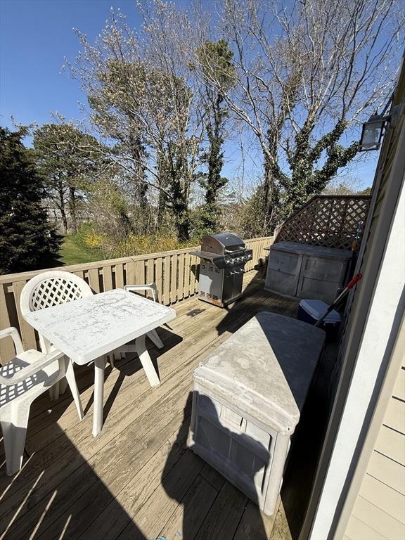 wooden terrace with grilling area and outdoor dining space