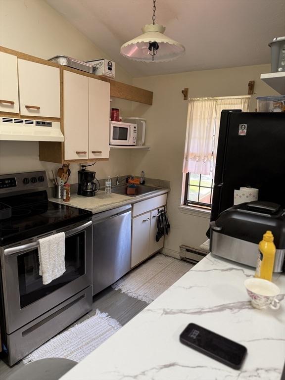 kitchen with stainless steel appliances, under cabinet range hood, a sink, a baseboard heating unit, and lofted ceiling