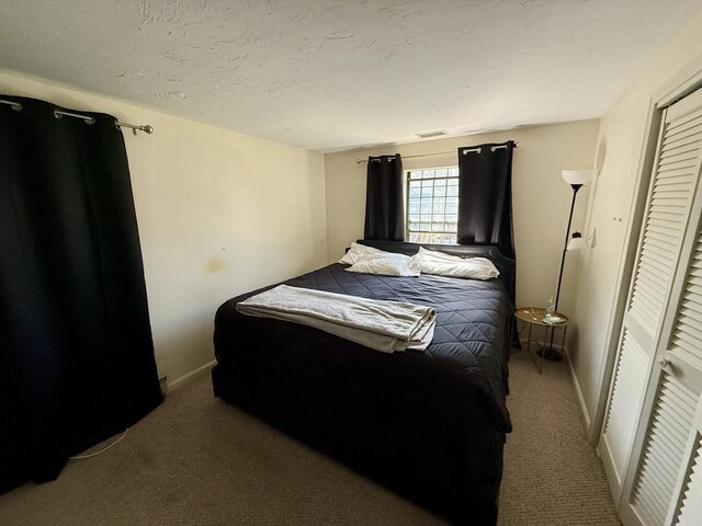 carpeted bedroom with baseboards and a closet