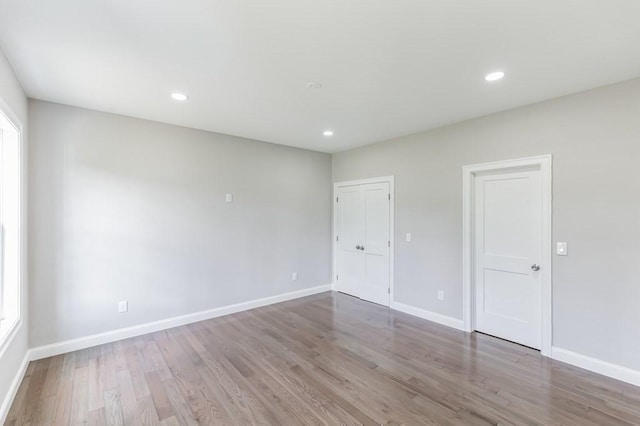 empty room featuring recessed lighting, baseboards, and wood finished floors