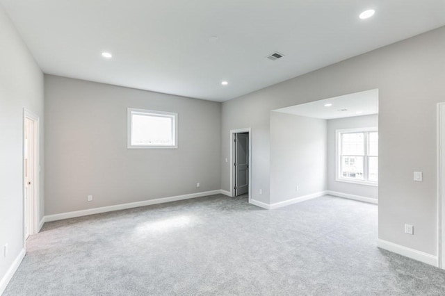 carpeted spare room featuring visible vents, recessed lighting, and baseboards