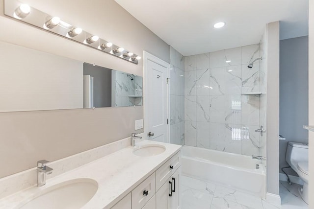 bathroom featuring double vanity, marble finish floor, toilet, and a sink