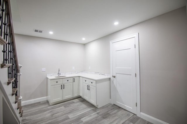 laundry room featuring recessed lighting, visible vents, light wood finished floors, and a sink