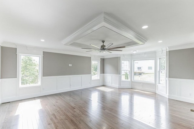 spare room with ornamental molding, recessed lighting, light wood-style floors, wainscoting, and ceiling fan