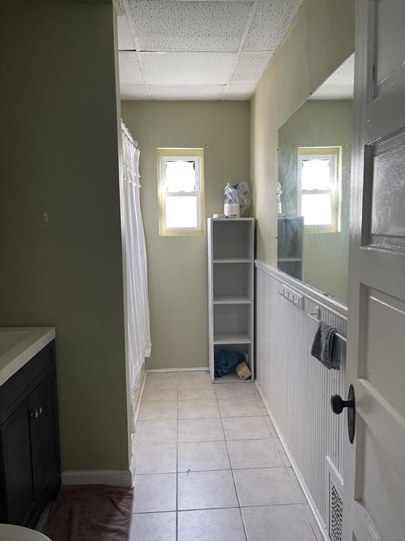 bathroom with a paneled ceiling, vanity, curtained shower, and tile patterned flooring