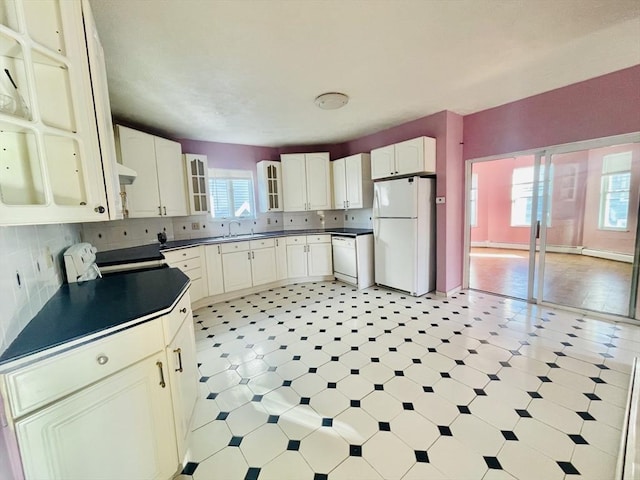 kitchen with white cabinetry, backsplash, white appliances, and sink