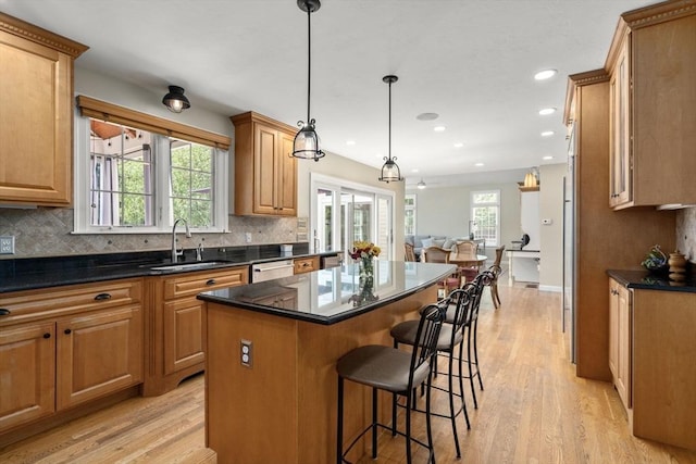63 High St, Shrewsbury, MA 01545 - kitchen featuring light wood-style floors, a kitchen island, a breakfast bar area, and a sink