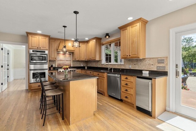 63 High St, Shrewsbury, MA 01545 - kitchen featuring a wealth of natural light, appliances with stainless steel finishes, a kitchen breakfast bar, and light wood-style flooring