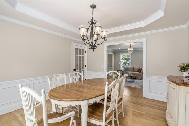 63 High St, Shrewsbury, MA 01545 - dining room featuring light wood finished floors, a wainscoted wall, crown molding, a chandelier, and a decorative wall