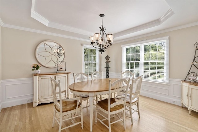 63 High St, Shrewsbury, MA 01545 - dining room with wainscoting, light wood-style flooring, a tray ceiling, and an inviting chandelier