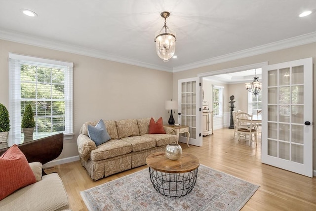 63 High St, Shrewsbury, MA 01545 - living area featuring crown molding, light wood finished floors, a notable chandelier, and french doors