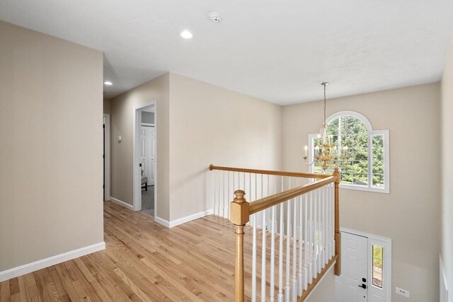 63 High St, Shrewsbury, MA 01545 - corridor featuring an upstairs landing, baseboards, an inviting chandelier, and light wood-style floors