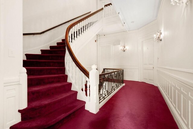 stairs with carpet and a decorative wall