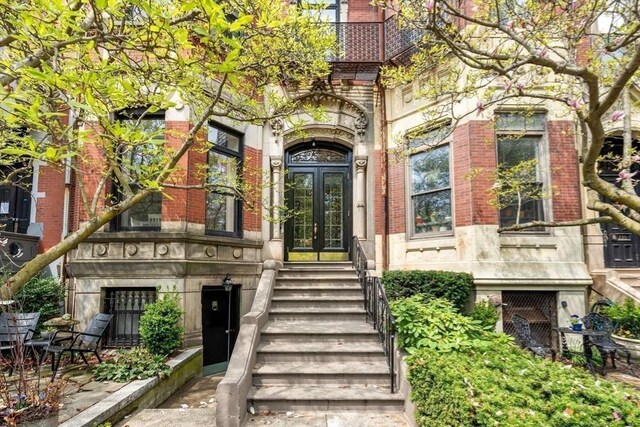 property entrance featuring brick siding, french doors, and stone siding
