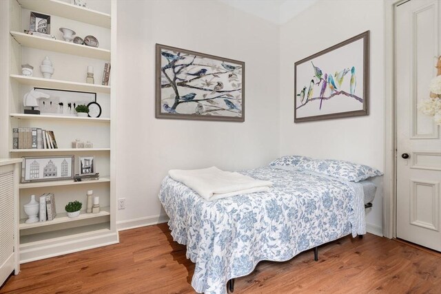 bedroom featuring baseboards and wood finished floors