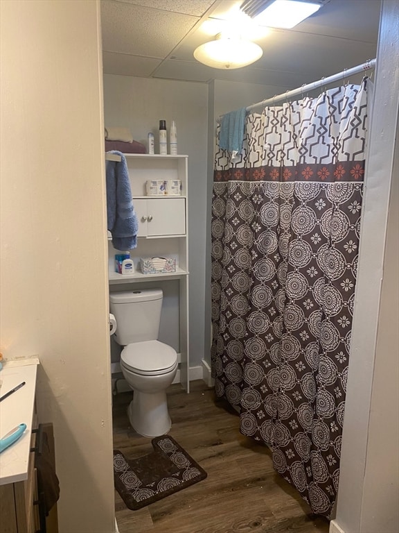 bathroom with toilet, hardwood / wood-style floors, a shower with shower curtain, vanity, and a paneled ceiling