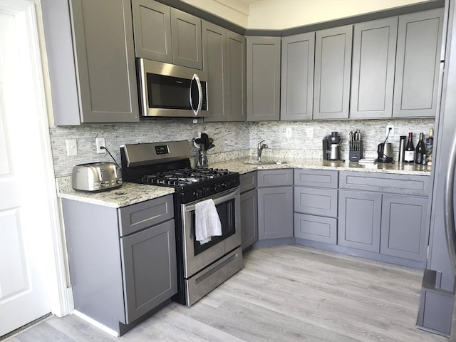 202 Broadway Unit 2-1, Lawrence, MA 01840 - kitchen featuring appliances with stainless steel finishes, gray cabinets, and backsplash