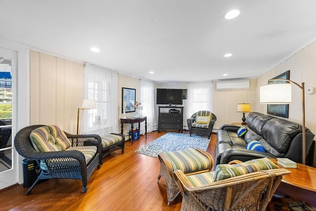 34 Kenwood Rd, Bourne, MA 02559 - living room with a wall mounted air conditioner, wood finished floors, ornamental molding, and recessed lighting