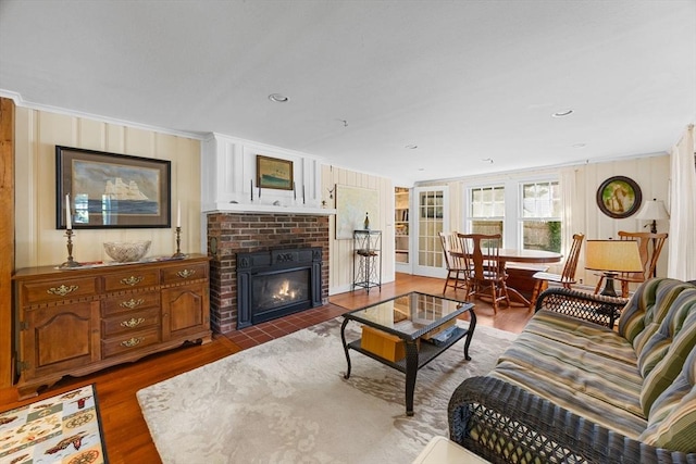 34 Kenwood Rd, Bourne, MA 02559 - living room featuring wood finished floors, a brick fireplace, and crown molding