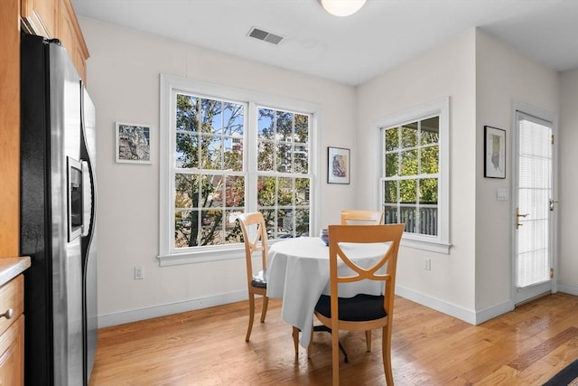 dining room featuring a healthy amount of sunlight and light hardwood / wood-style flooring