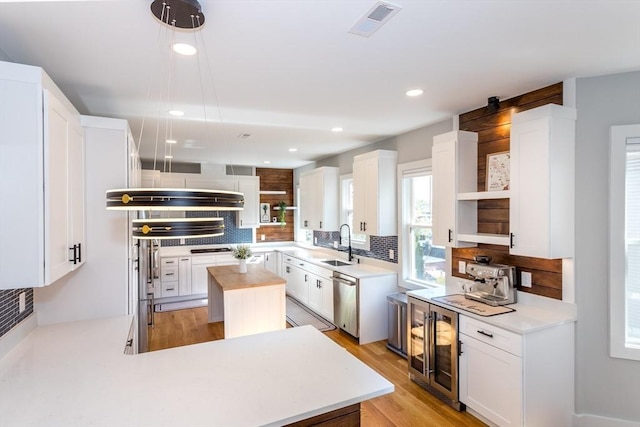 61 Paul Revere Rd Unit 2, Arlington, MA 02476 - kitchen with beverage cooler, a sink, open shelves, white cabinets, and tasteful backsplash