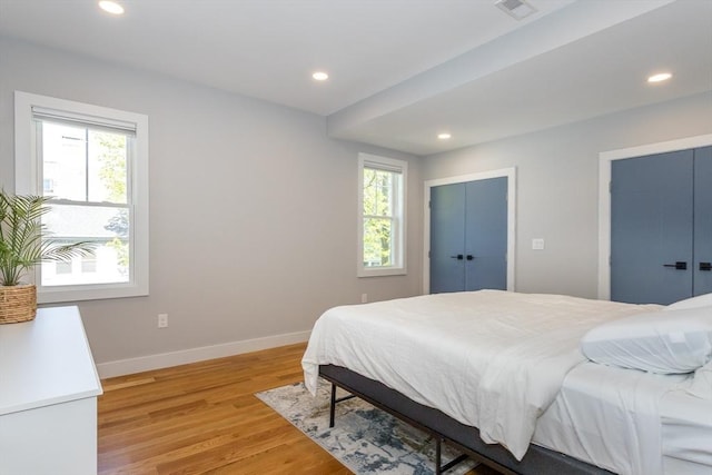 61 Paul Revere Rd Unit 2, Arlington, MA 02476 - bedroom featuring light wood-style flooring, two closets, visible vents, baseboards, and recessed lighting