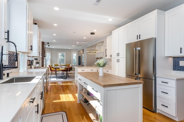 61 Paul Revere Rd Unit 2, Arlington, MA 02476 - kitchen with recessed lighting, light wood finished floors, wooden counters, tasteful backsplash, and high end refrigerator