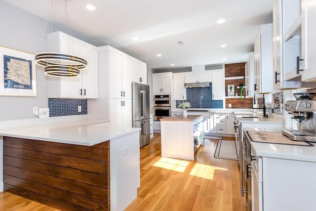 61 Paul Revere Rd Unit 2, Arlington, MA 02476 - kitchen with light countertops, stainless steel appliances, tasteful backsplash, and light wood-style floors