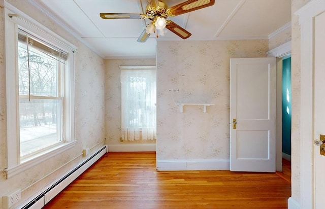 spare room featuring ceiling fan, a baseboard radiator, ornamental molding, and light hardwood / wood-style flooring