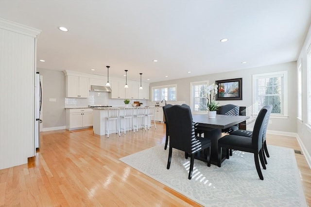 dining room featuring sink and light hardwood / wood-style flooring