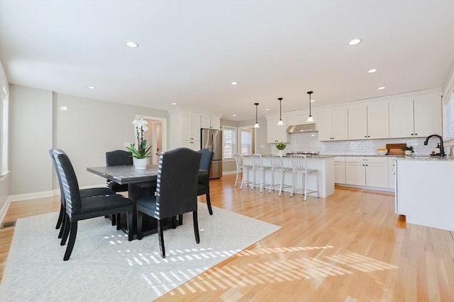 dining area featuring sink and light hardwood / wood-style flooring