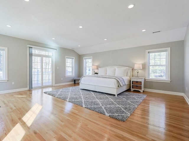 bedroom featuring multiple windows, access to outside, and light hardwood / wood-style flooring