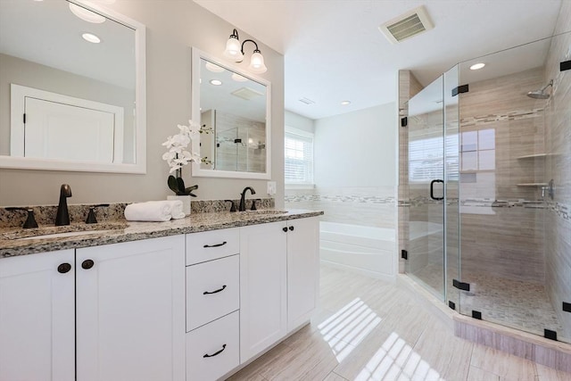 bathroom featuring vanity and shower with separate bathtub