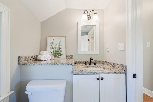 bathroom featuring lofted ceiling, vanity, and toilet